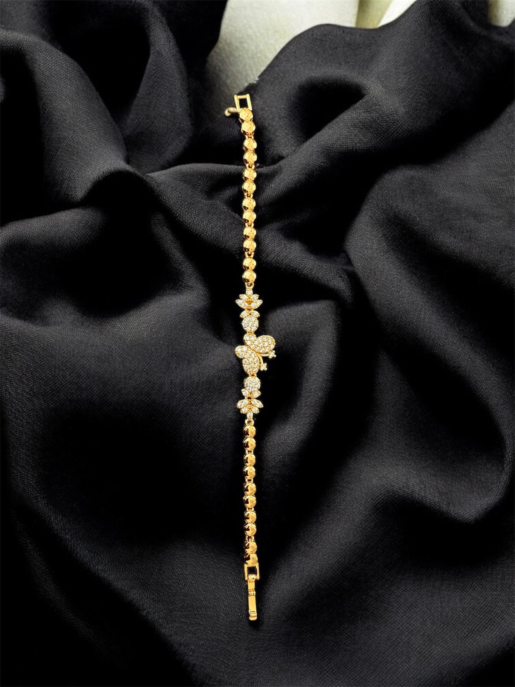 18k Gold-plated bracelet with diamond accents on a black fabric background