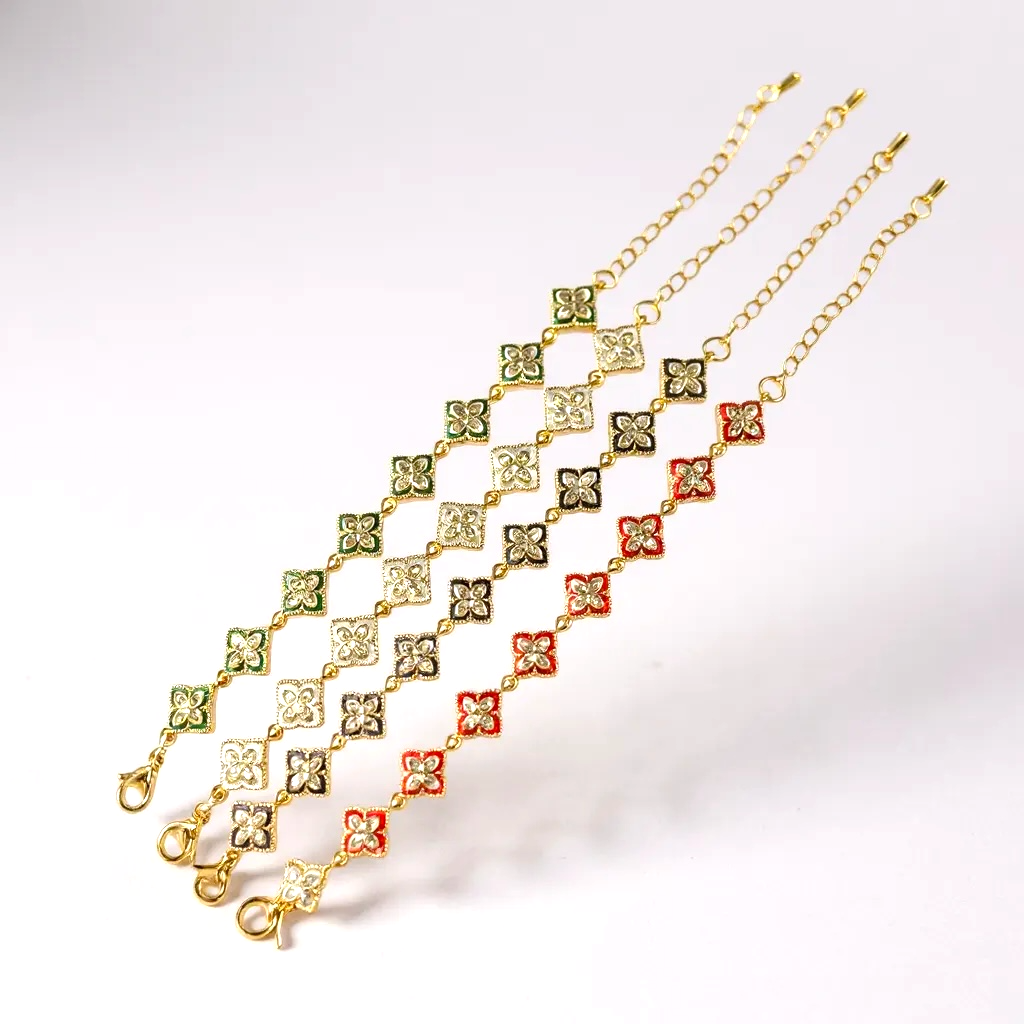 Three gold chains with floral designs on a white background