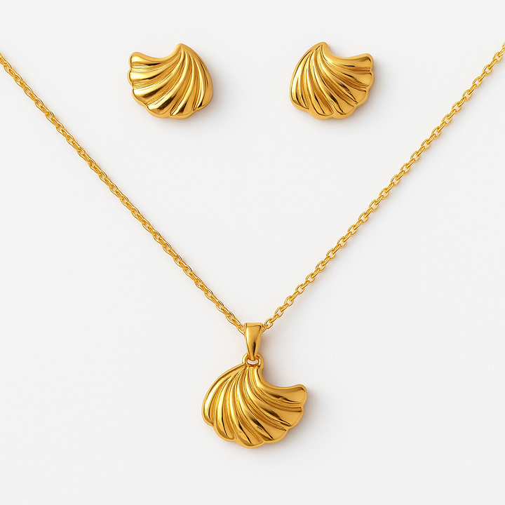 Gold necklace and earrings set on a white background