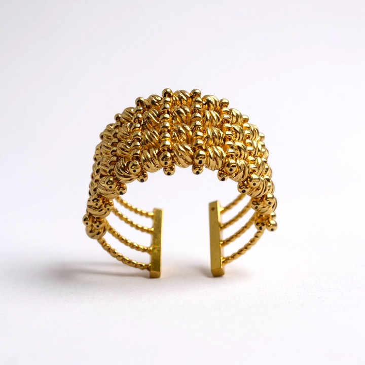 Gold beaded ring on a white background
