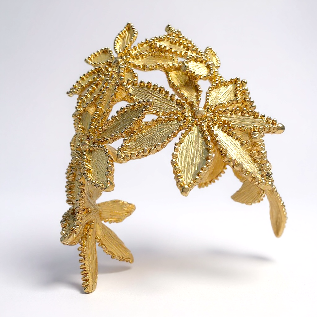 Gold leaf-shaped cuff bangle on a white background