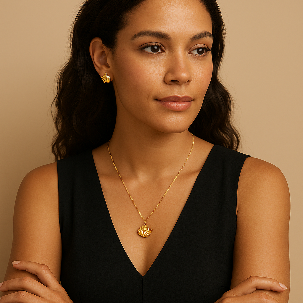 Woman wearing gold earrings and necklace against a beige background