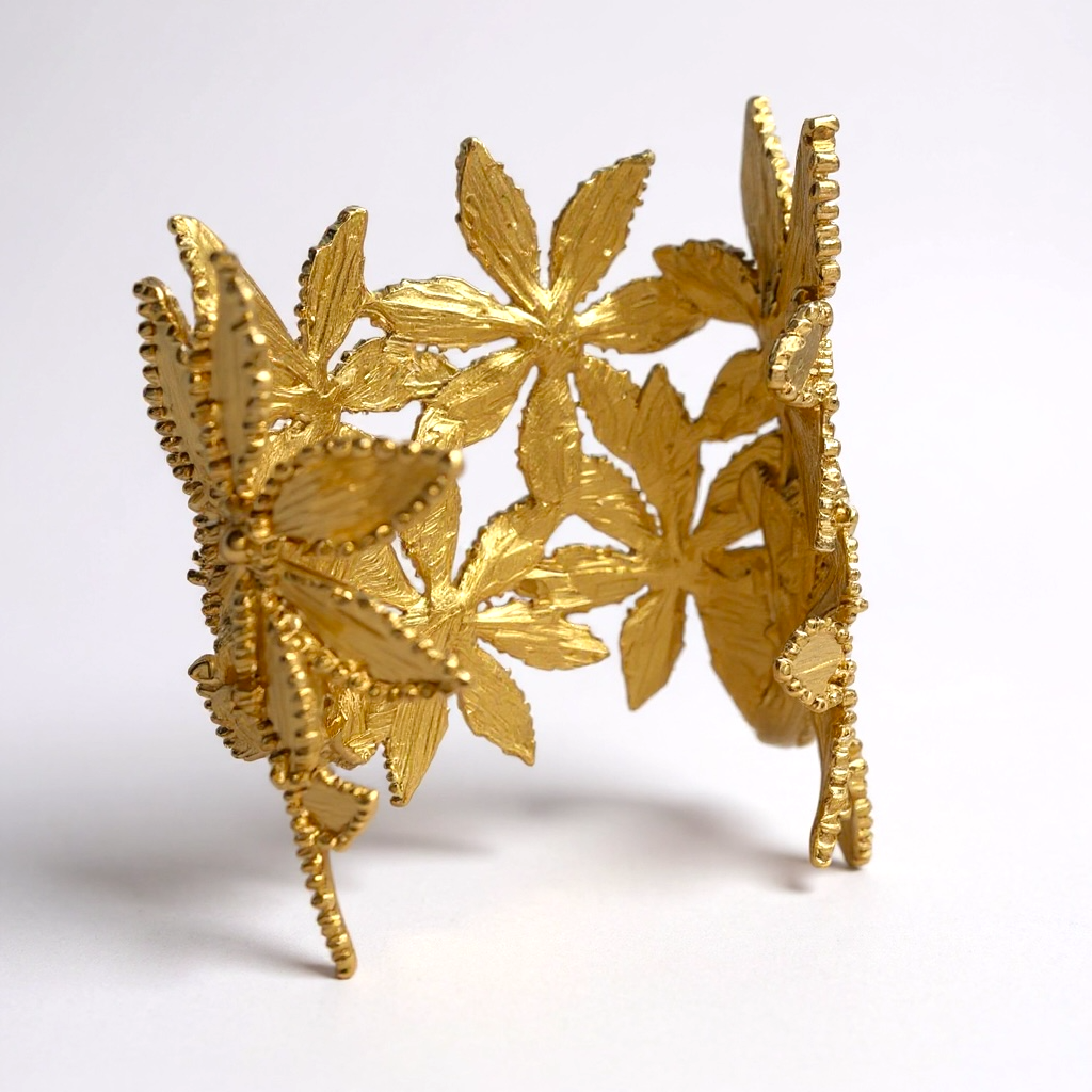 Gold leaf-shaped cuff bracelet on a white background