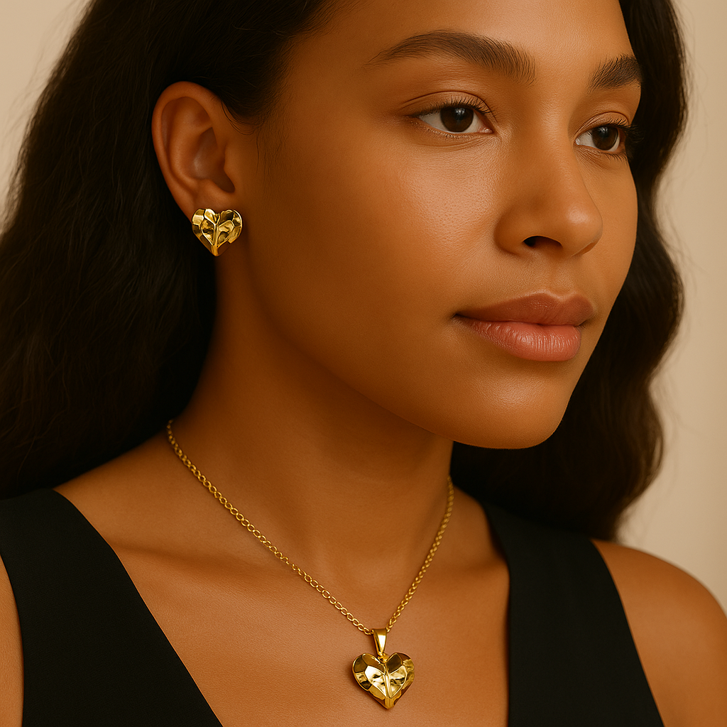 Woman wearing gold heart-shaped earrings and necklace against a neutral background