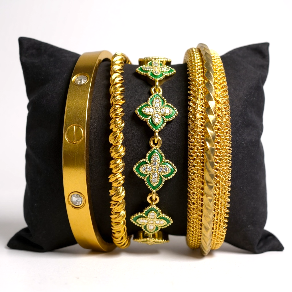 Set of gold and green jewelry on a black pillow